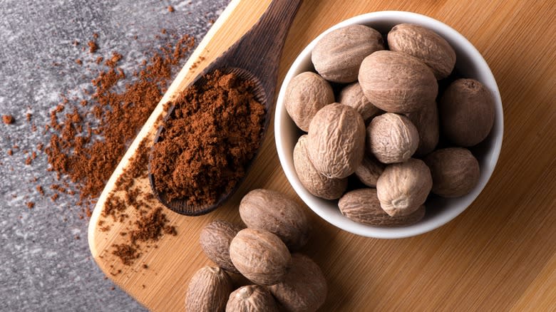 Whole nutmeg in a bowl with grounds