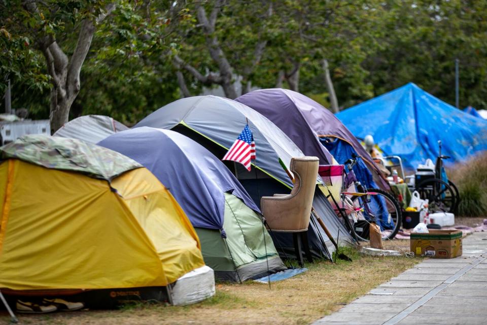 A row of tents with a chair, a bike, a wheelchair and an American flag