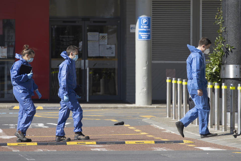 Police forensic staff walk outside a supermarket in Auckland, New Zealand, Saturday, Sept. 4, 2021. New Zealand authorities say they shot and killed a violent extremist, Friday Sept. 3, after he entered a supermarket and stabbed and injured six shoppers. Prime Minister Jacinda Ardern described Friday's incident as a terror attack. (AP Photo/Brett Phibbs)