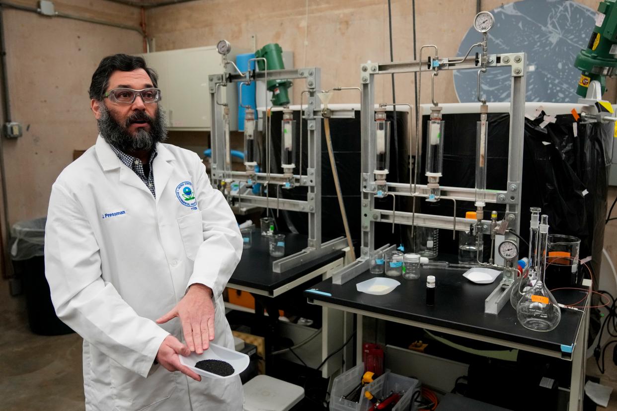 Jonathan Pressman holds a sample of activated carbon in the Drinking Water Pilot Plant at the U.S. Environmental Protection Agency’s Andrew W. Breidenbach Environmental Research Center in Cincinnati. The Drinking Water Pilot Plant conducts research with a focus on drinking water treatment technologies to remove contaminants, including PFAS.