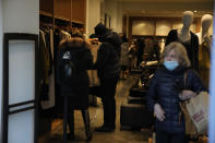 People shop inside a store on Oxford Street in London, Monday, Nov. 29, 2021. Countries around the world slammed their doors shut again to try to keep the new omicron variant at bay Monday, even as more cases of the mutant coronavirus emerged and scientists raced to figure out just how dangerous it might be. In Britain, mask-wearing in shops and on public transport will be required, starting Tuesday. (AP Photo/Matt Dunham)