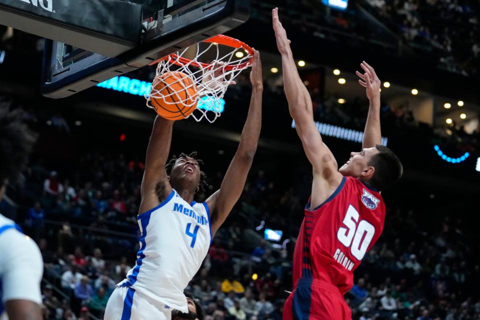 Memphis forward Chandler Lawson (4) gets a basket on a dunk in front of Florida Atlantic center Vladislav Goldin (50) in the first half of a first-round college basketball game in the men's NCAA Tournament in Columbus, Ohio, Friday, March 17, 2023. (AP Photo/Michael Conroy)
