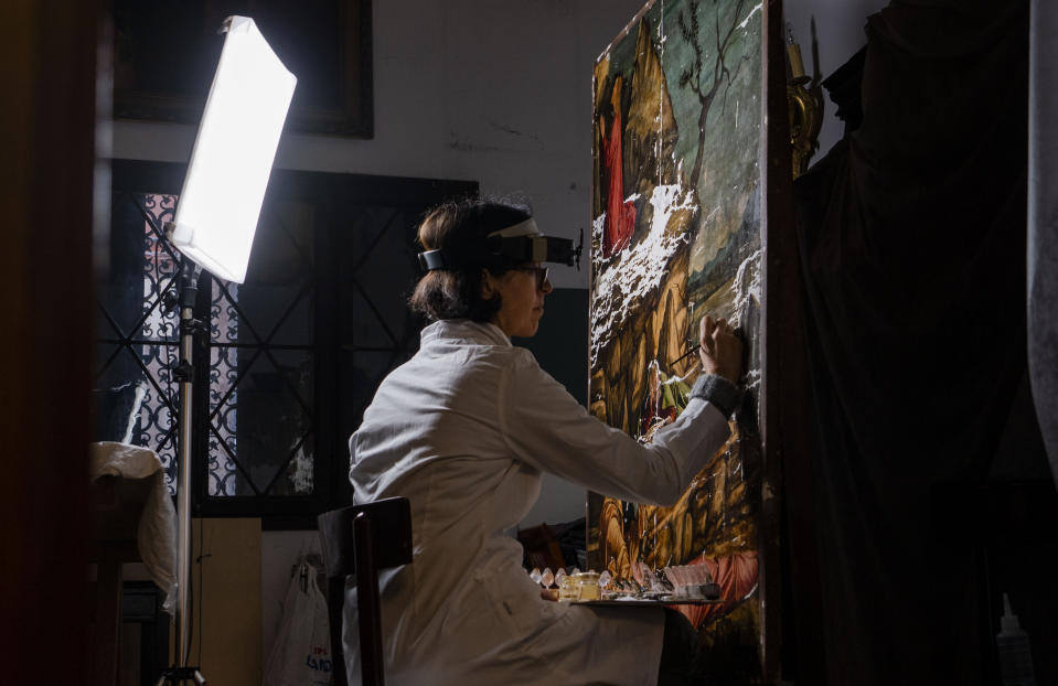 Restorer Valentina Piovan works on Vittore Carpaccio's 1502 painting 'The agony in the garden' at the Dalmatian School in Venice, northern Italy, Wednesday, Dec. 7, 2022. On November 20th, the National Gallery of Washington inaugurated the first retrospective exhibition of Carpaccio’s works outside of Italy. It will run until February 12, 2023. (AP Photo/Domenico Stinellis)