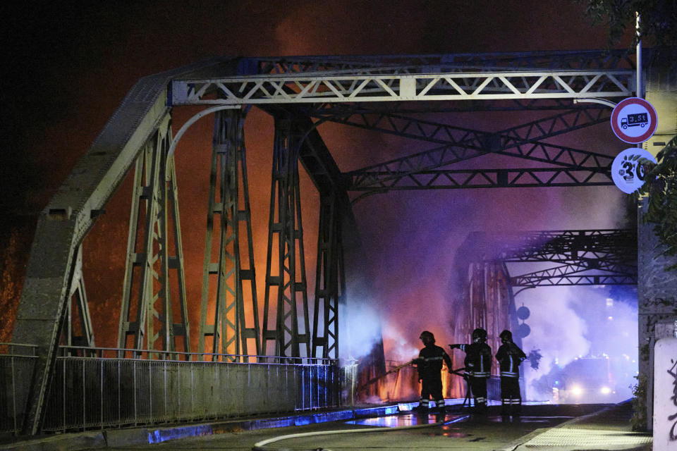 Firefighters work to extinguish flames engulfing the Industry Bridge in Rome, early Sunday, Oct. 3, 2021. A blaze, possibly sparked by a gas canister explosion, destroyed part of an historic bridge spanning the Tiber River in Rome before firefighters extinguished the flames early Sunday. (Mauro Scrobogna/LaPresse via AP)