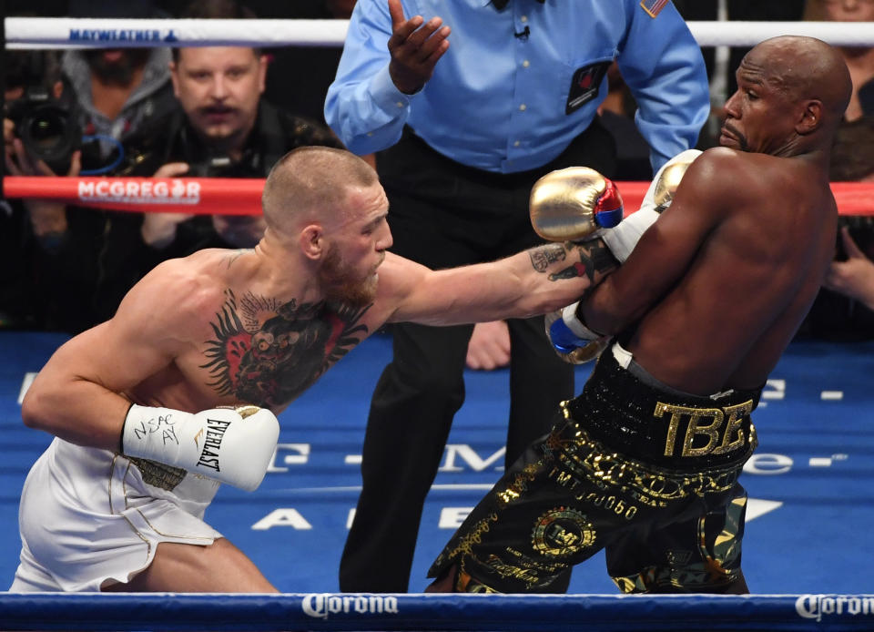 LAS VEGAS, NV - AUGUST 26:  (L-R) Conor McGregor throws a punch at Floyd Mayweather Jr. during their super welterweight boxing match on August 26, 2017 at T-Mobile Arena in Las Vegas, Nevada.  (Photo by Ethan Miller/Getty Images)