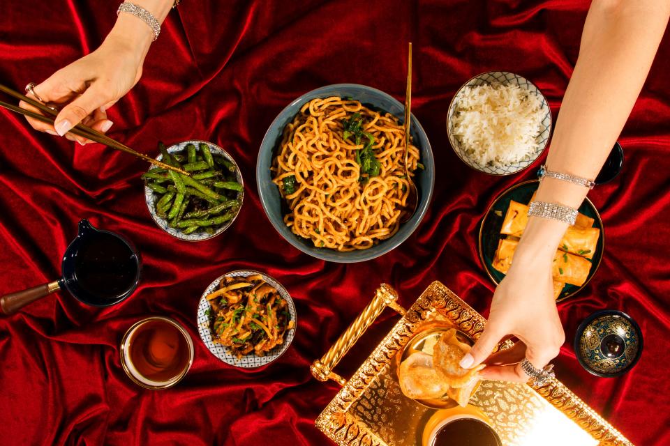 Women's hands picking up Chinese food