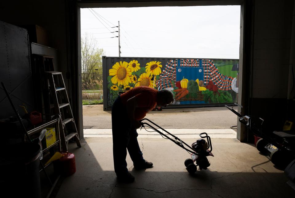 Mike Ream, a supervisor at ModCon Living Tool Library, starts up a mini-tiller to make sure it works before giving it to a "borrower."