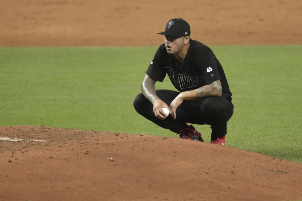 Philadelphia Phillies starting pitcher Vince Velasquez kneels on the mound after hitting Miami Marlins third baseman Brian Anderson with a pitch with the bases loaded during the third inning of a baseball game, Friday, Aug. 23, 2019, in Miami. (AP Photo/Lynne Sladky)