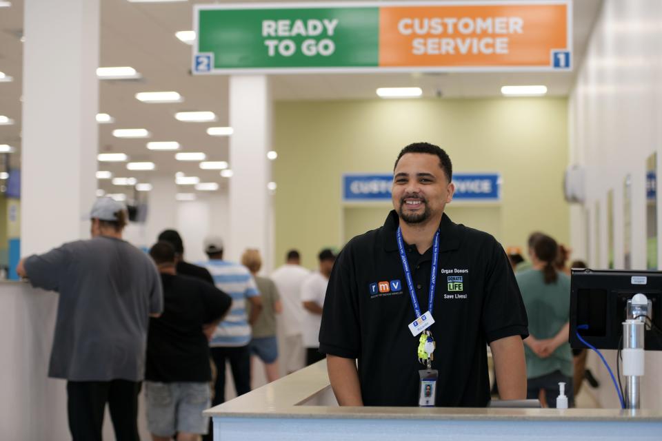 An employee at the entrance directs customers to the proper line or area. The new RMV opened Monday in the former Big Y supermarket off Route 20.