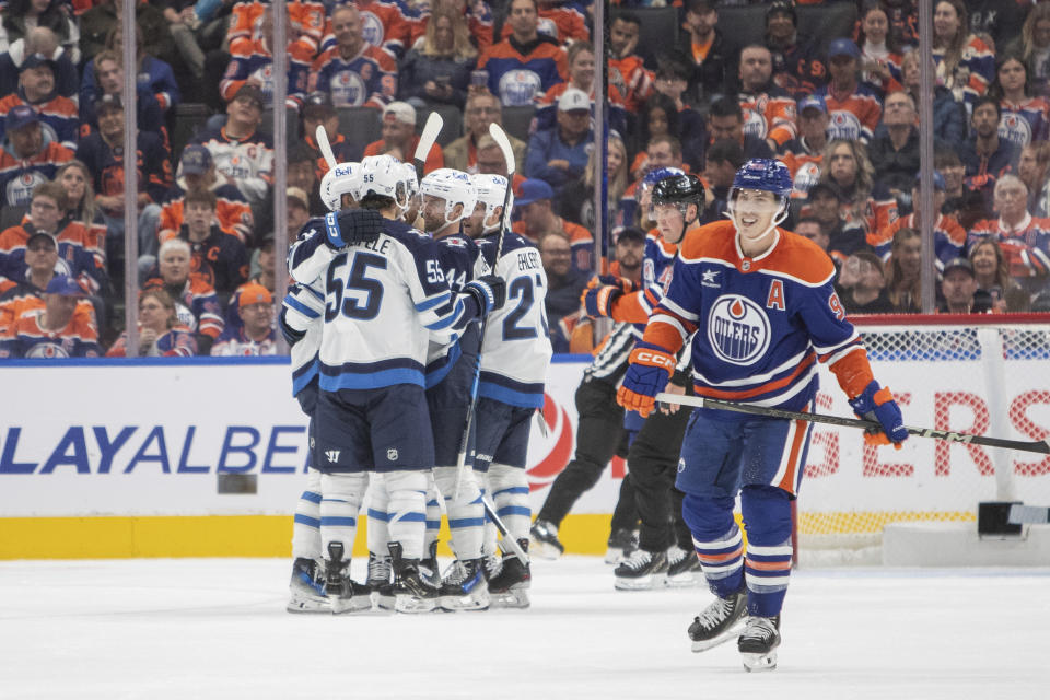 Winnipeg Jets players celebrate a goal as Edmonton Oilers' Ryan Nugent-Hopkins (93) reacts during second period NHL action in Edmonton, Alberta, Wednesday, Oct. 9, 2024. (Amber Bracken/The Canadian Press via AP)