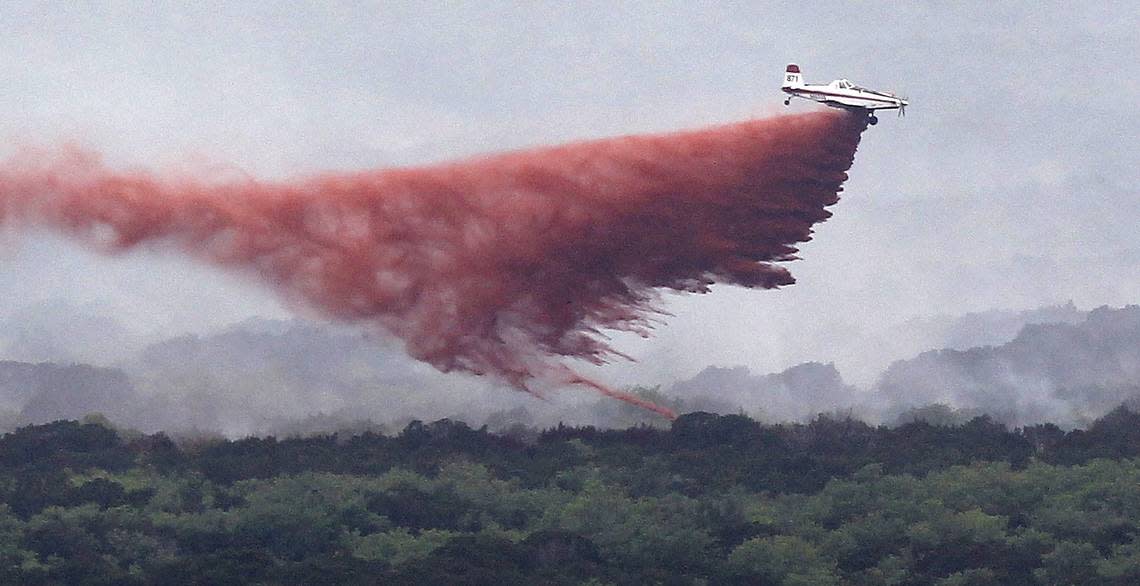Air cranes drop fire retardant on smoldering areas in the countryside around Possum Kingdom Lake on April 20, 2011.