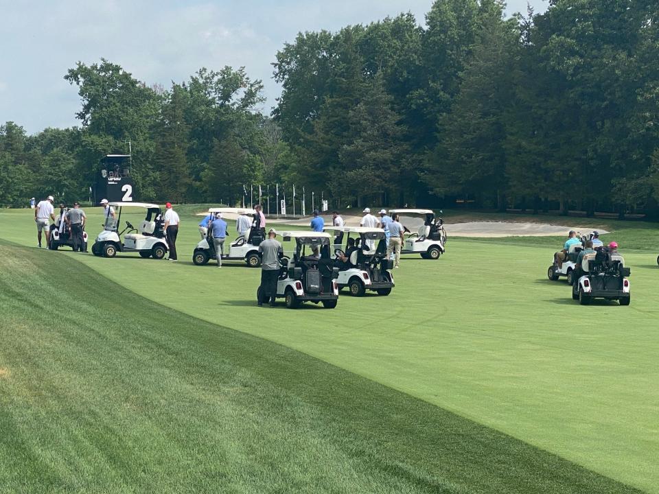 Several golf carts scramble across the fairway.