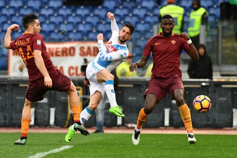 Makeshift Napoli forward Dries Mertens (C) shoots as Roma defenders Kostas Manolas (L) and Antonio Rudiger look on during Italian Serie A match at the Olympic Stadium in Rome on March 4, 2017