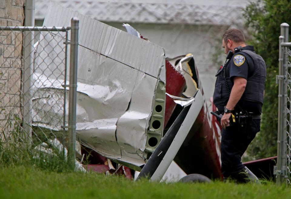 A Milwaukee Police Officer works at the scene of a small plane crash near North 103rd Street and Courtland Avenue in Wauwatosa on Thursday. The plane crashed in the backyard of a home.