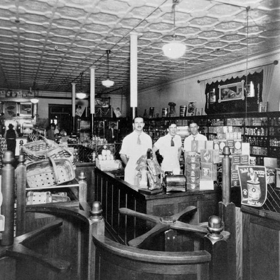 Publix founder George Jenkins in uniform standing behind the cash register at work in a Publix history archive photo. Jenkins founded his chain of Publix supermarkets in Florida in the 1930s.