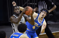 Oregon forward Eugene Omoruyi (2) hauls in a rebound next to UCLA guard Jaime Jaquez Jr. (4) during the first half of an NCAA college basketball game Wednesday, March 3, 2021, in Eugene, Ore. (AP Photo/Andy Nelson)