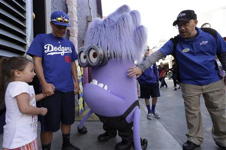 A purple Minion character meets park visitors at the new "Despicable Me Minion Mayhem" ride during technical rehearsals for the new attraction at Universal Studios Hollywood in Universal City, California March 28, 2014. REUTERS/Jonathan Alcorn