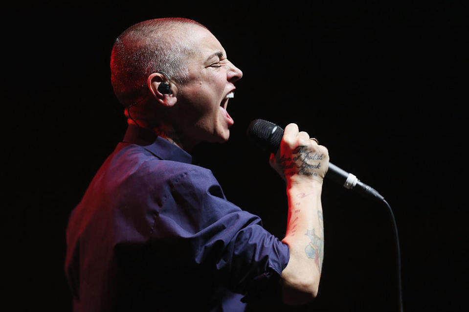 Sinead O'Connor performing on stage, singing into the microphone