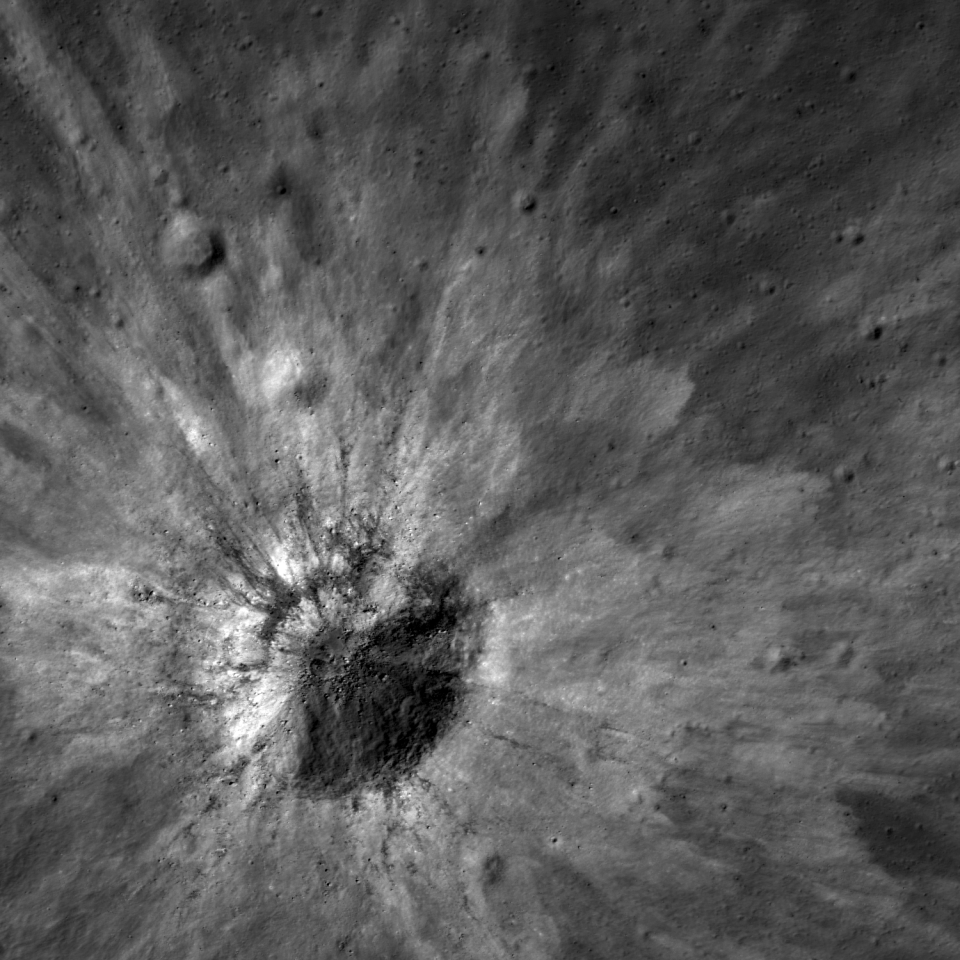 High-reflectance ejecta and low-reflectance impact melt streamers surround this fresh impact crater. This image was released June 20, 2013.