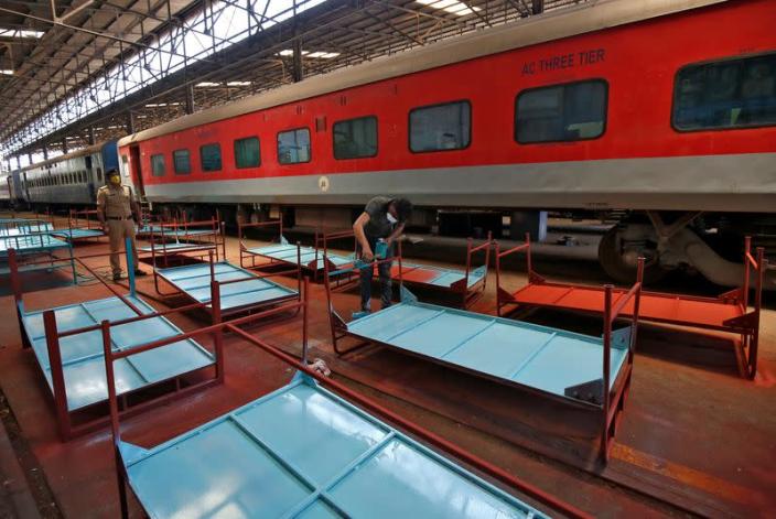 A worker paints beds to be used at a railway hospital to accommodate people suffering from coronavirus disease (COVID-19) amid concerns about the spread of the disease, in Chennai
