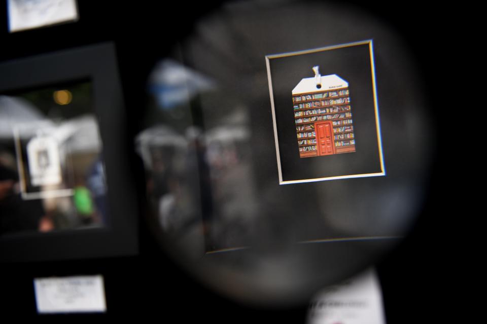 Blake Gore's miniature art is seen through a magnifying at his booth during Artisphere on Friday, May 10, 2024.