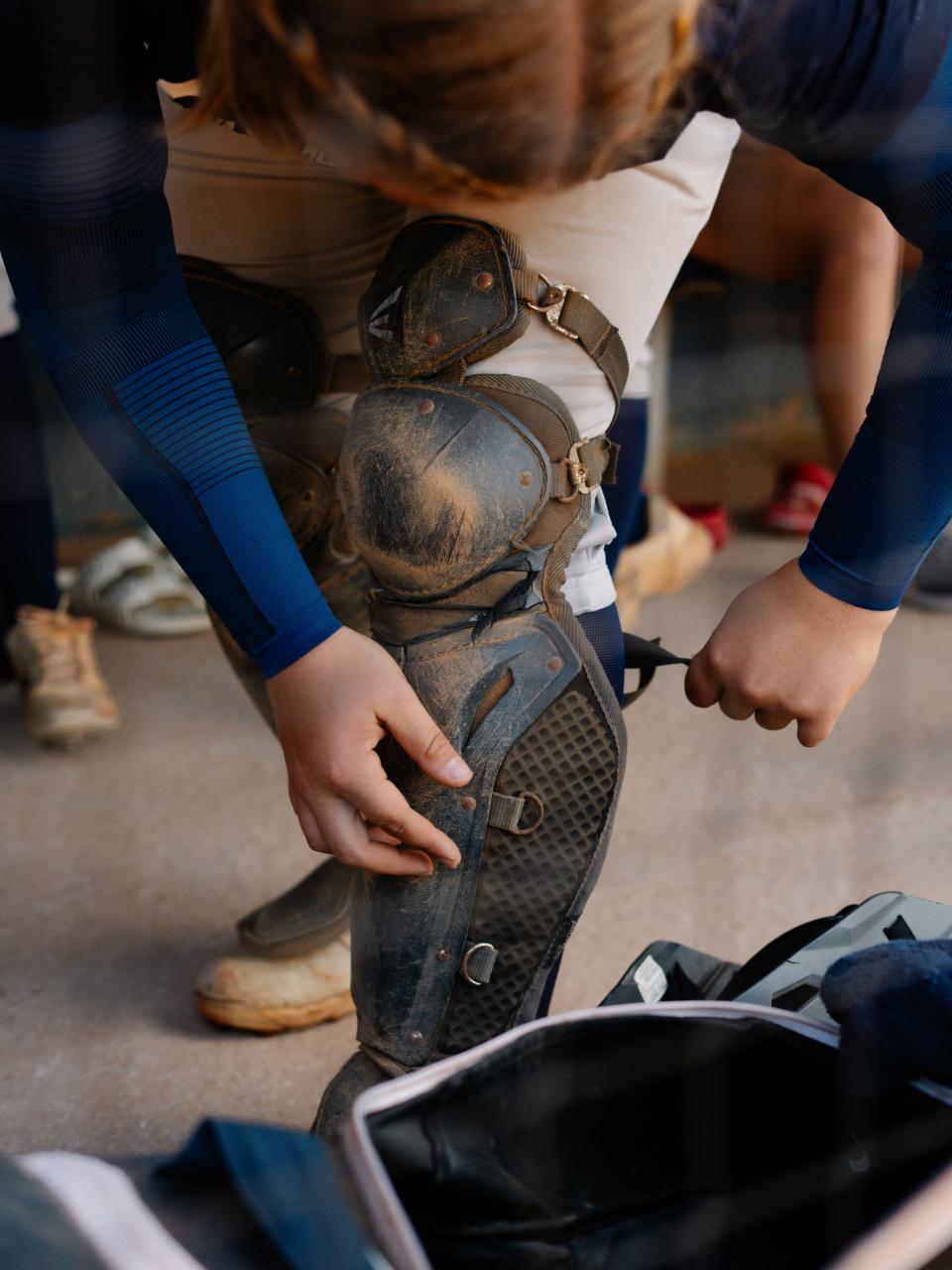Hutzler dons protective gear during softball practice. (Martina Tuaty for The Washington Post)