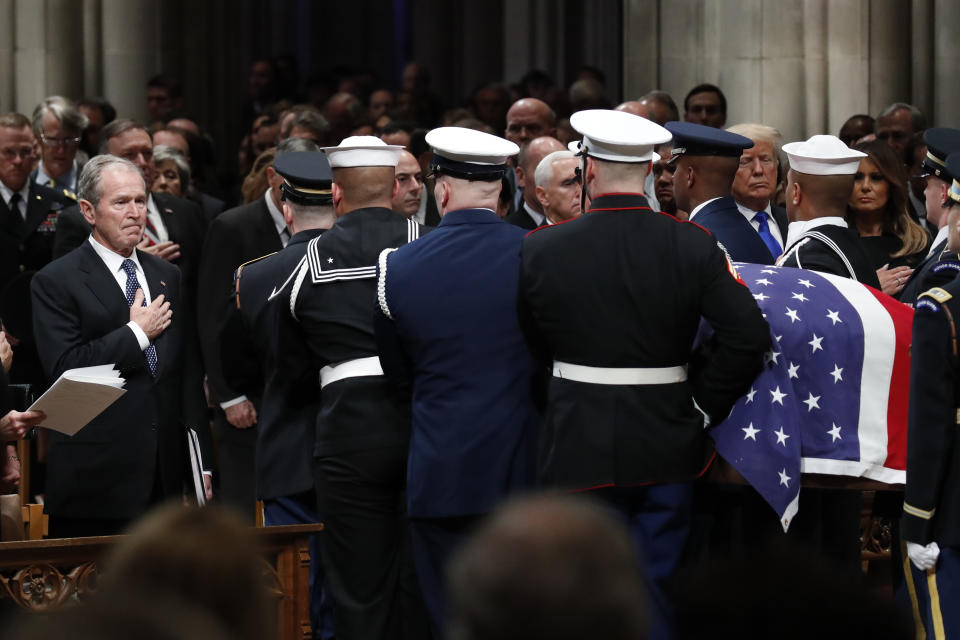 Former President George W. Bush places his hand over his heart as the flag-draped casket of former President George H.W. Bush is carried by a joint services military honor guard after the State Funeral at the National Cathedral, Wednesday, Dec. 5, 2018, in Washington. (Photo: Alex Brandon, Pool/AP)