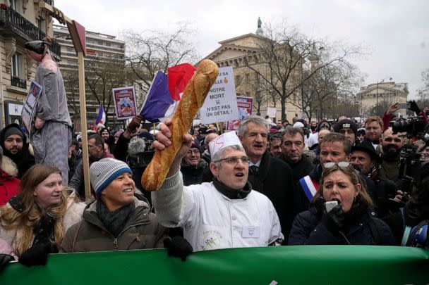 PHOTO: A baker clutches a baguette during a demonstration Monday, Jan. 23, 2023, in Paris. (Michel Euler/AP)