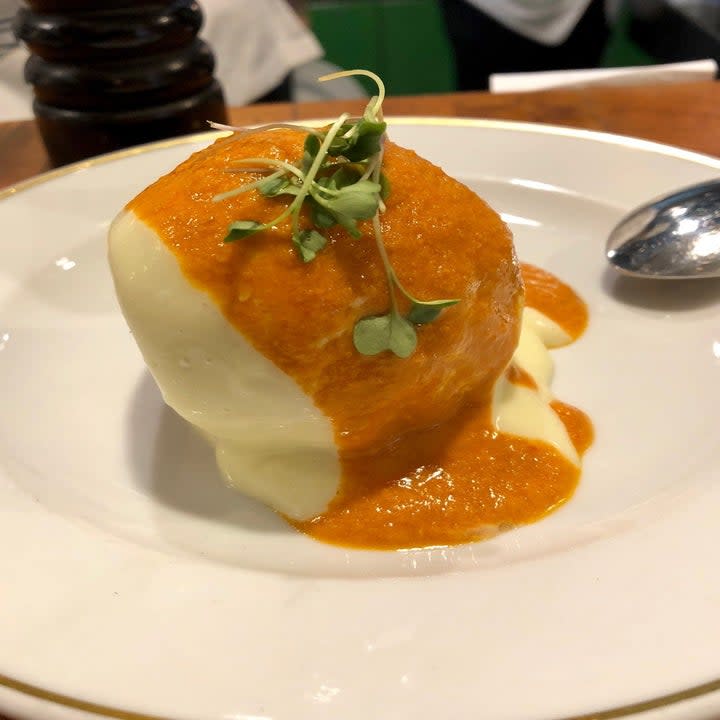 A large croquette topped in brava sauce.