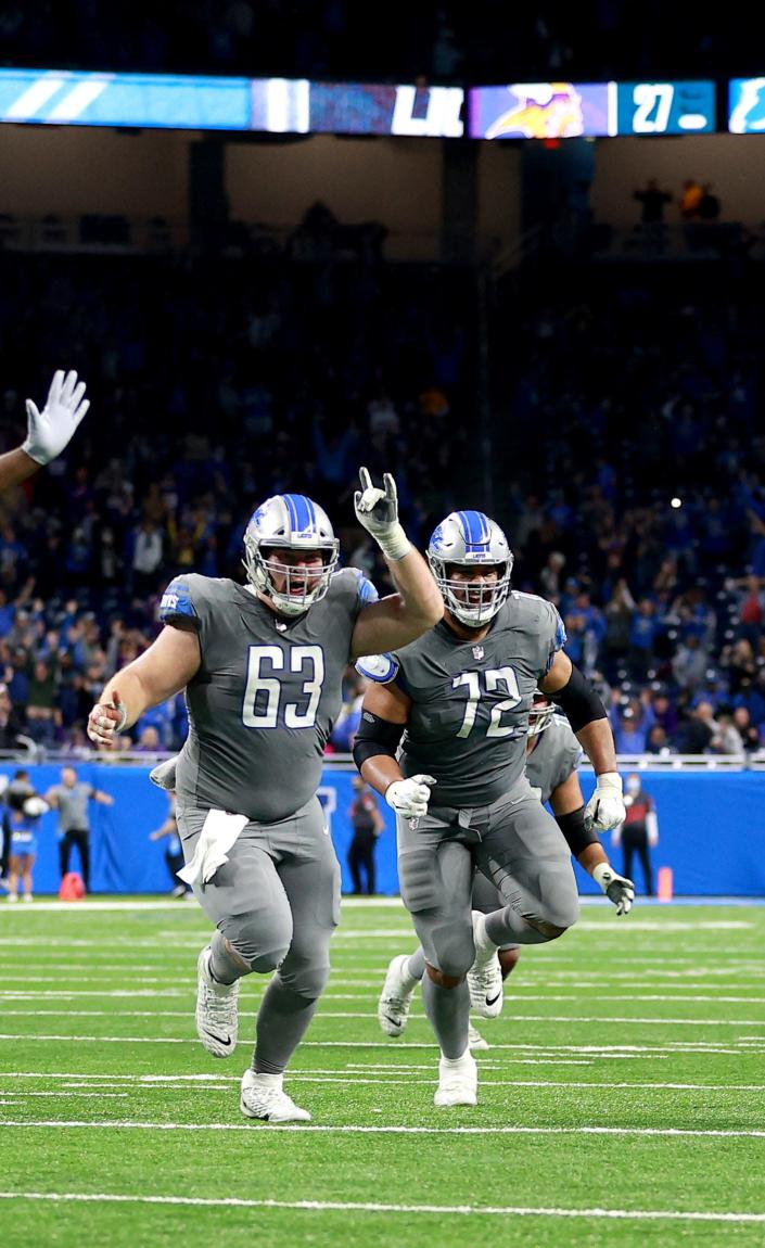Lions offensive linemen Evan Brown, left, and Halapoulivaati Vaitai celebrate after the 29-27 win over the Vikings on Dec. 5, 2021, at Ford Field.
