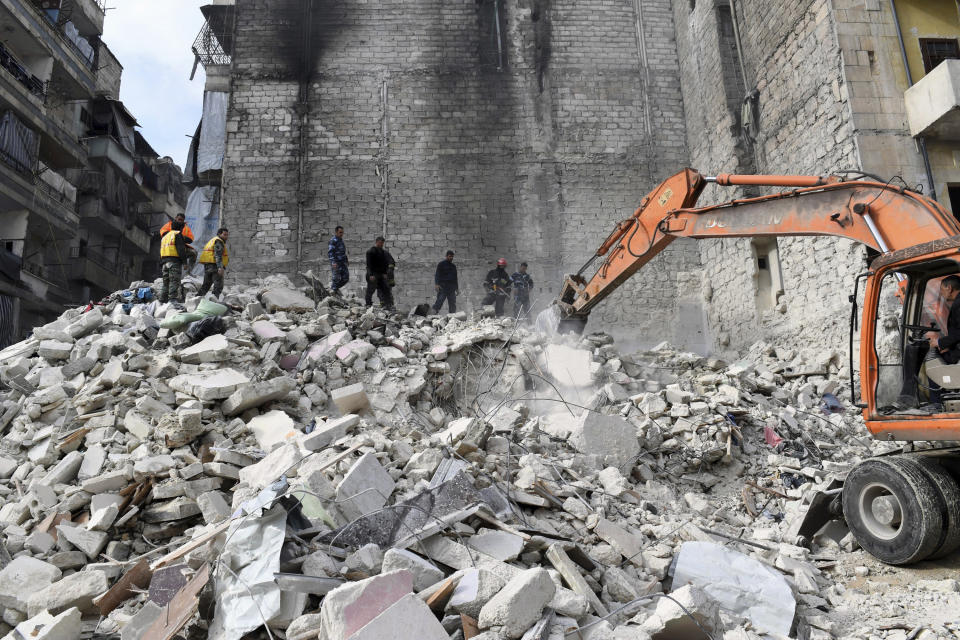 In this photo released by the Syrian official news agency SANA, people inspect a destroyed building where, according to SANA, the five-story building collapsed early Saturday, Feb. 2, 2019, killing most of those who were inside and only one person was rescued alive, in the northern city of Aleppo, Syria. SANA said that a building damaged during years of war in the northern city of Aleppo has collapsed killing 11 people. (SANA via AP)