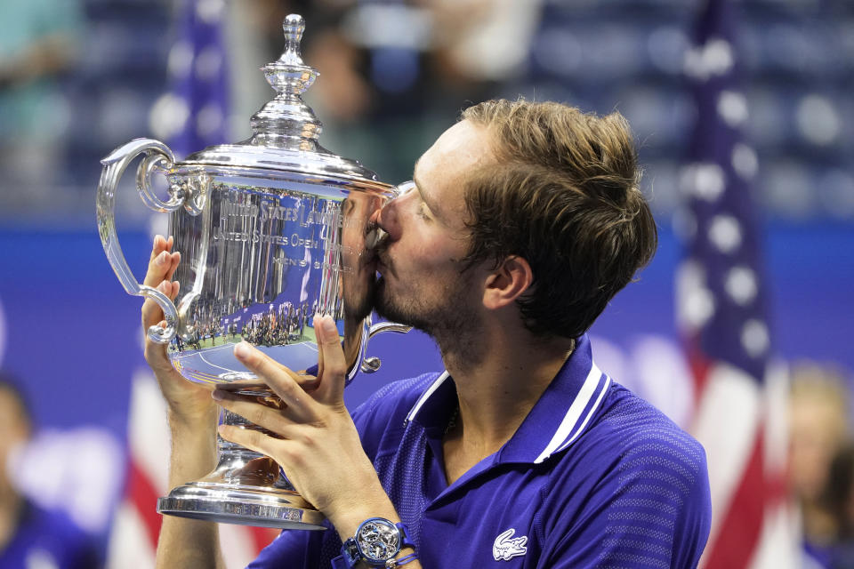 FILE - Daniil Medvedev, of Russia, kisses the championship trophy after defeating Novak Djokovic, of Serbia, in the men's singles final of the U.S. Open tennis championships, Sunday, Sept. 12, 2021, in New York. The ATP men’s professional tennis tour will not award ranking points for Wimbledon this year because of the All England Club’s ban on players from Russia and Belarus over the invasion of Ukraine. The ATP announced its decision Friday night, May 20, 2022, two days before the start of the French Open — and a little more than a month before play begins at Wimbledon on June 27. It is a highly unusual and significant rebuke of the oldest Grand Slam tournament. (AP Photo/John Minchillo, File)