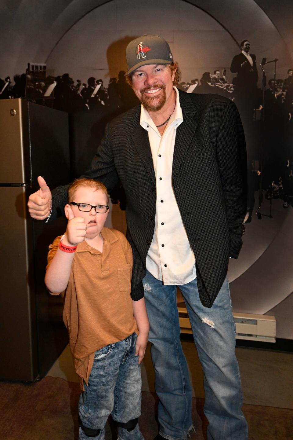 Denton Padgett, a former resident at OK Kids Korral, poses for a photo with country music superstar and OK Kids Korral founder Toby Keith at the 18th annual Toby Keith & Friends Golf Classic May 20 at The Criterion in Oklahoma City.