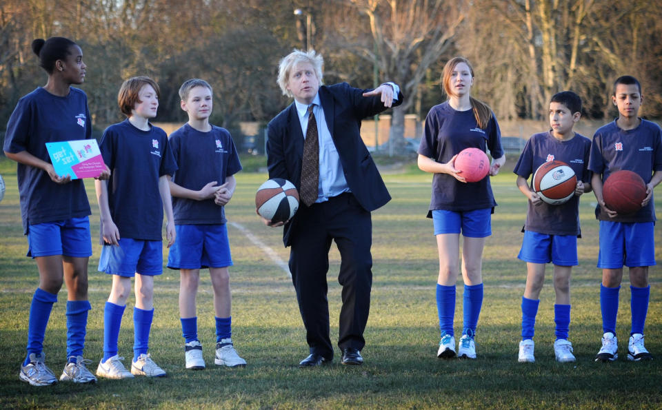 London Mayor Boris Johnson throws balls in the air with pupils from Chiswick Community School in west London where he and London 2012 Chairman Lord Coe told the school how many Olympic tickets they would receive through the London 2012 Ticketshare scheme.