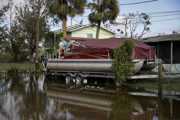 A resident sits on a boat on a flooded street following Hurricane Ian in Fort Myers, Florida, US, on Thursday, Sept. 29, 2022. Hurricane Ian, one of the strongest hurricanes to hit the US, weakened to a tropical storm but continues to dump rain on the state as it makes its way up the US Southeast. Photographer: Eva Marie Uzcategui/Bloomberg via Getty Images