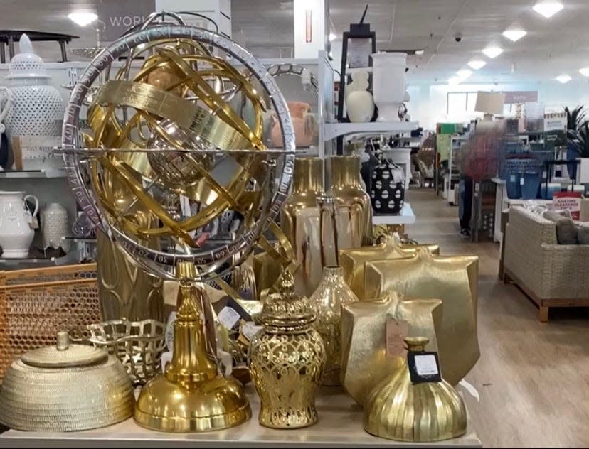 gold statues and vases on a table display in a homegoods store