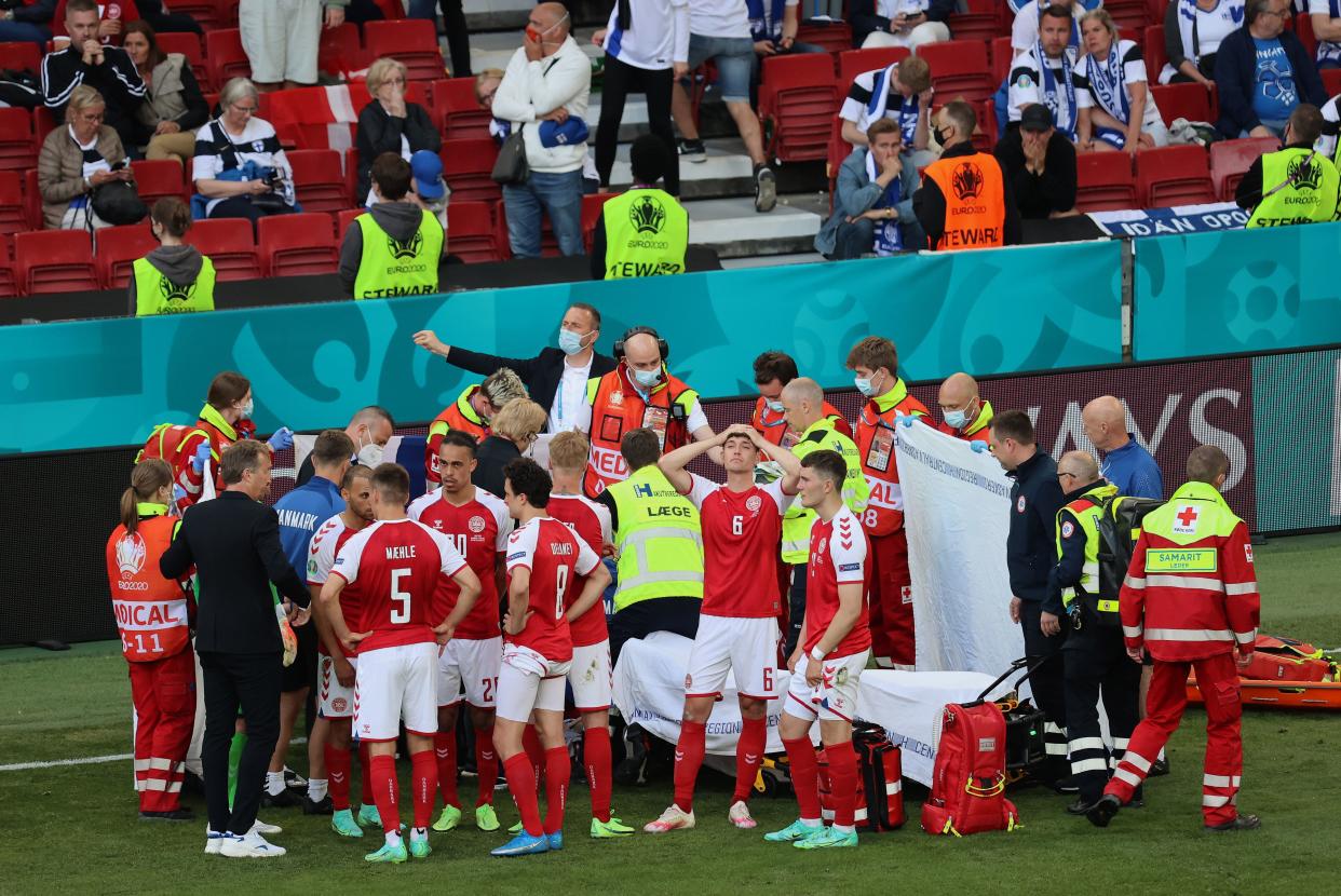 Denmark's players gather around teammate Christian Eriksen, who collapsed on the pitch during a match between Denmark and Finland at the Parken Stadium in Copenhagen on Saturday. (Photo: Wolfgang Rattay - Pool via Getty Images)