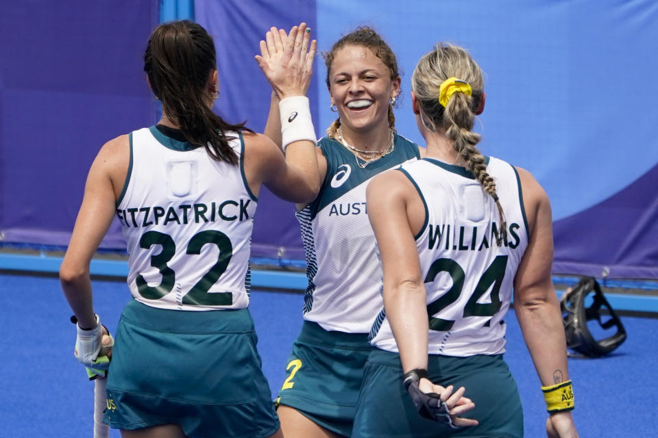 Australia's Ambrosia Malone, center, celebrates after scoring on China goalkeeper Dongxiao Li during a women's field hockey match at the 2020 Summer Olympics, Monday, July 26, 2021, in Tokyo, Japan. (AP Photo/John Minchillo)