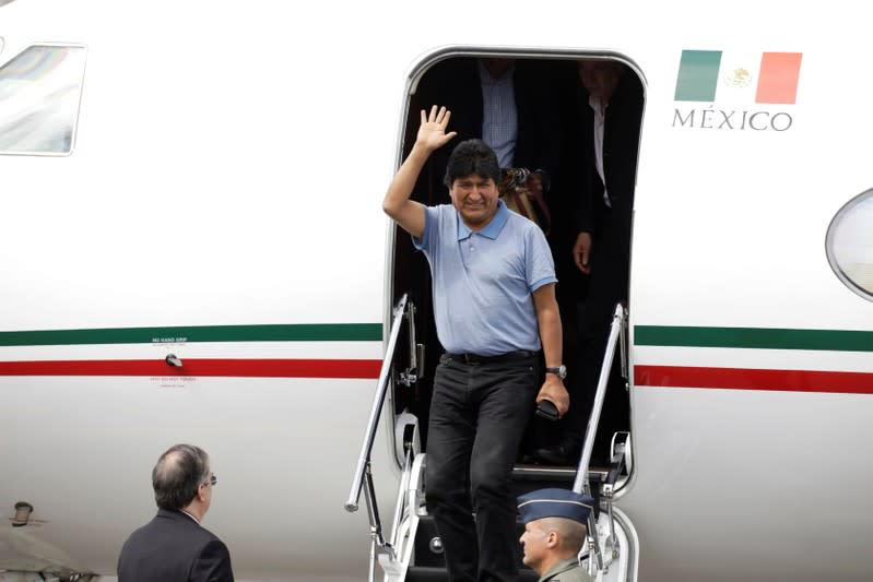 Bolivia's ousted President Evo Morales waves during his arrival to take asylum in Mexico, in Mexico City