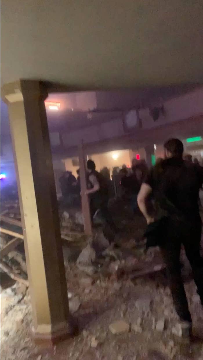 People try to sift through debris from a collapsed roof amid a storm in Belvidere, Illinois, on March 31, 2023, in this screengrab from a social media video.