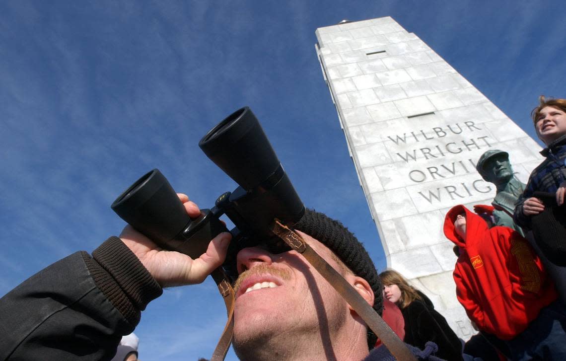 Visitors to the Wright Brothers Memorial in Kill Devil Hills, N.C. watch as planes fly over in 2002 to commemorate the 99th anniversary of the first flight.