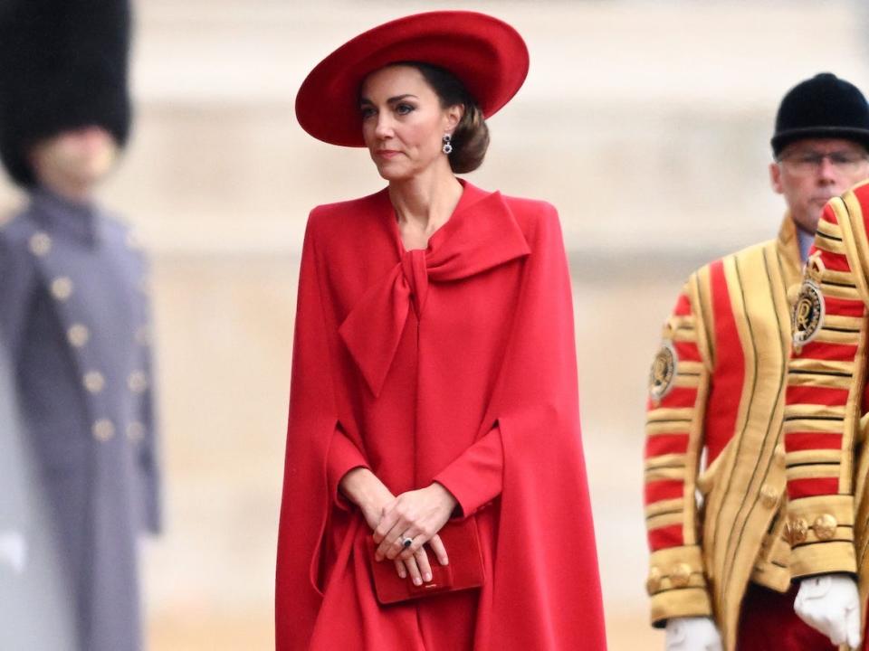 Kate Middleton walks in a red coat dress.