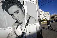 Pedestrians pass a tour bus with an image of Elvis shortly after Tennessee Gov. Bill Lee unveiled new legislation on Wednesday, Jan. 10, 2024, in Nashville, Tenn., designed to protect songwriters, performers and other music industry professionals against the rise in artificial intelligence. (AP Photo/John Amis)
