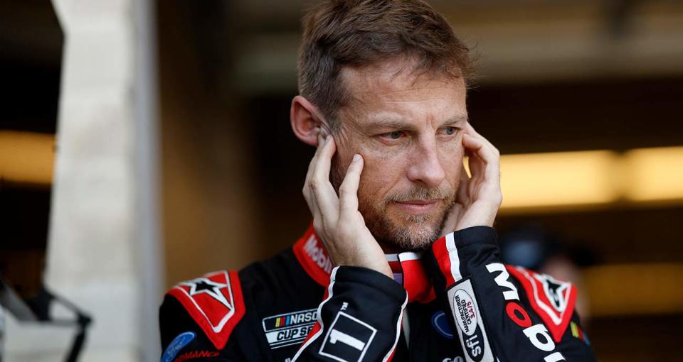 Jenson Button covers his ears in the NASCAR Cup Series garage at the Circuit of The Americas