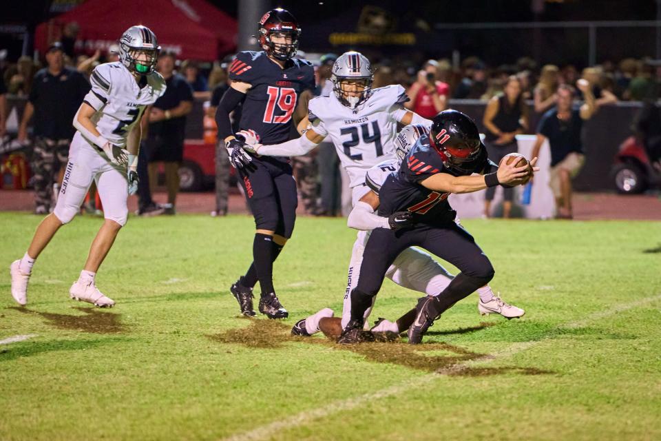 Liberty Lions junior quarterback Hayden Fletcher (11) reaches out for the end zone as he is tackled by the Hamilton Huskies at Liberty High School in Peoria, on Friday, Aug. 25, 2023.