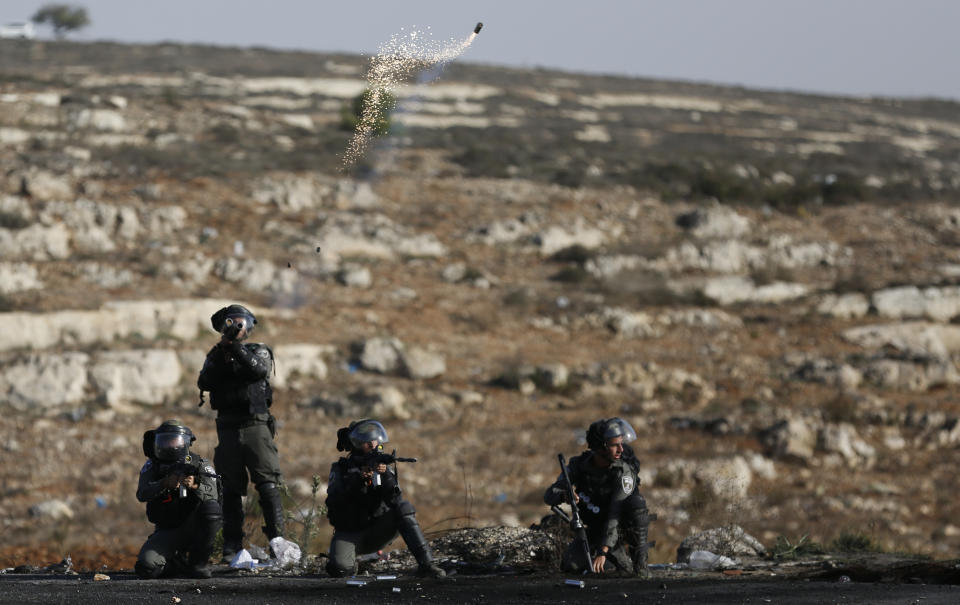 Israeli troops fire teargas as they clash with Palestinians during the protest against the U.S. announcement that it no longer believes Israeli settlements violate international law., at checkpoint Beit El near the West Bank city of Ramallah, Tuesday, Nov. 26, 2019, (AP Photo/Majdi Mohammed)