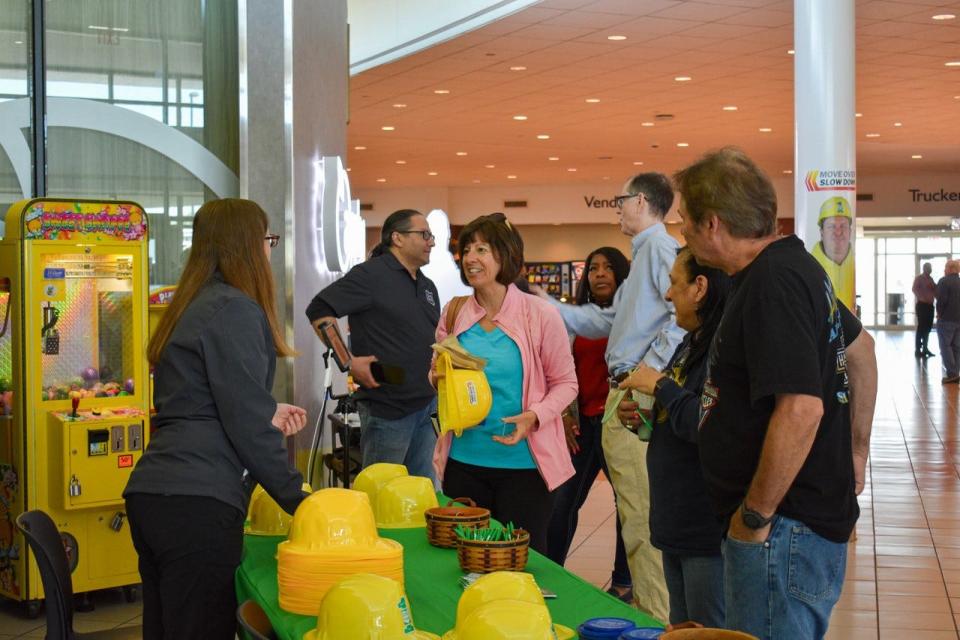 Visitors win giveaways at the prize wheel while Charles Cyrill of the Ohio Turnpike, second from left, talks to travelers at the Commodore Perry Service Plaza on May 26.