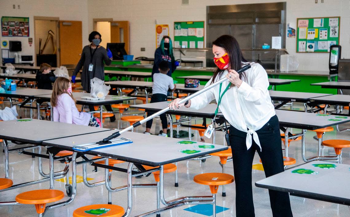 Lisa Brown, principal of Green Elementary School, sanitizes cafeteria tables, March 15, 2021 at the Raleigh school.