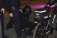 A demonstrator sits on the pavement after having been arrested by NYPD officers during a march through the West Village, Thursday, Nov. 5, 2020, in New York. (AP Photo/Seth Wenig)