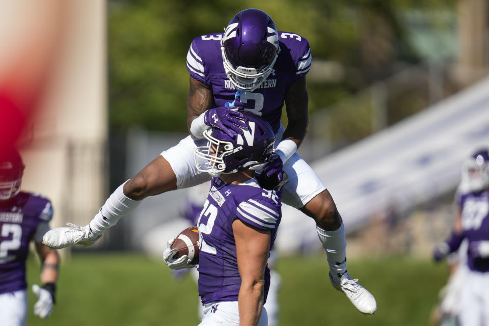 Northwestern defensive back Jaheem Joseph, top, jumps on linebacker Bryce Gallagher after Gallagher intercepted a pass from UTEP during the first half of an NCAA college football game Saturday, Sept. 9, 2023, in Evanston, Ill. (AP Photo/Erin Hooley)